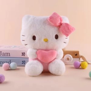 Pelúcia da Hello Kitty branca com laço rosa na orelha, segurando um coração rosa