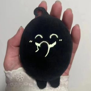 Pelúcia preta do Krobus, de Stardew Valley, com rosto bordado sorridente, na palma da mão