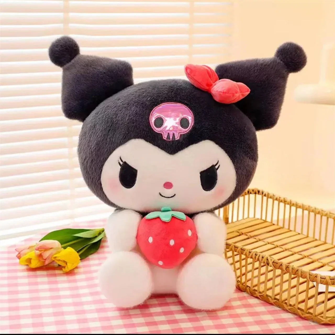 Pelúcia da Kuromi com 25 cm segurando um morango de pelúcia, sentada em frente a uma persiana