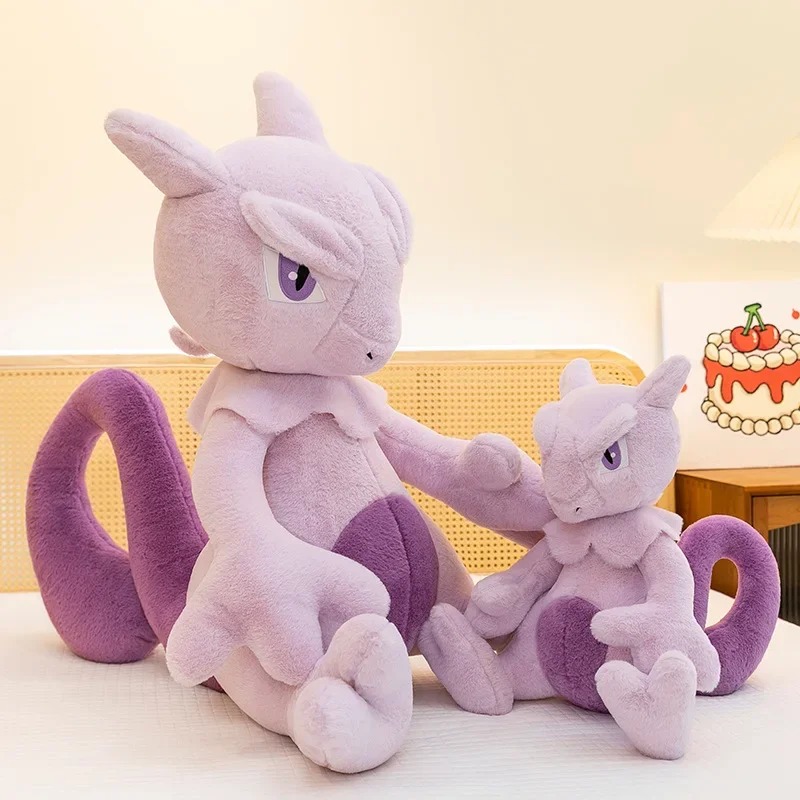 Duas pelúcias do Mewtwo de tamanhos diferentes sobre uma cama, com a cauda roxa curvada