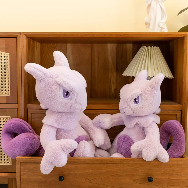 Duas pelúcias do Mewtwo em uma estante de madeira