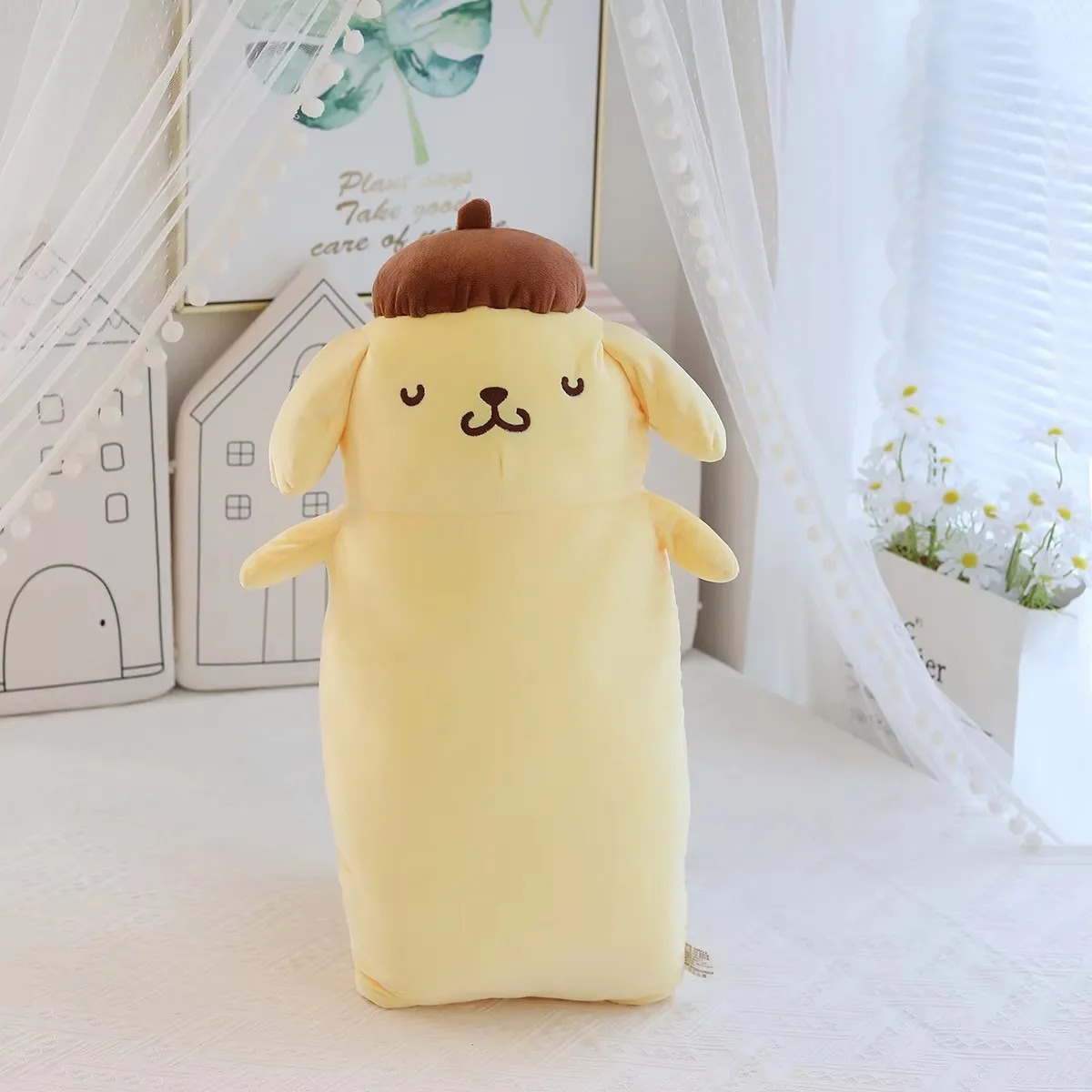 Pelúcia longa do Pompompurin com olhos fechados, de pé em frente a uma cortina