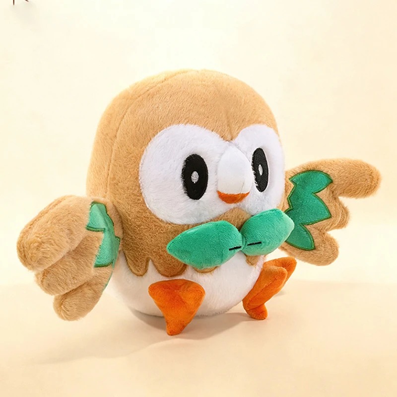 Pelúcia do Rowlet, de Pokémon, de frente, com gravatinha de folhas verdes e pés laranja