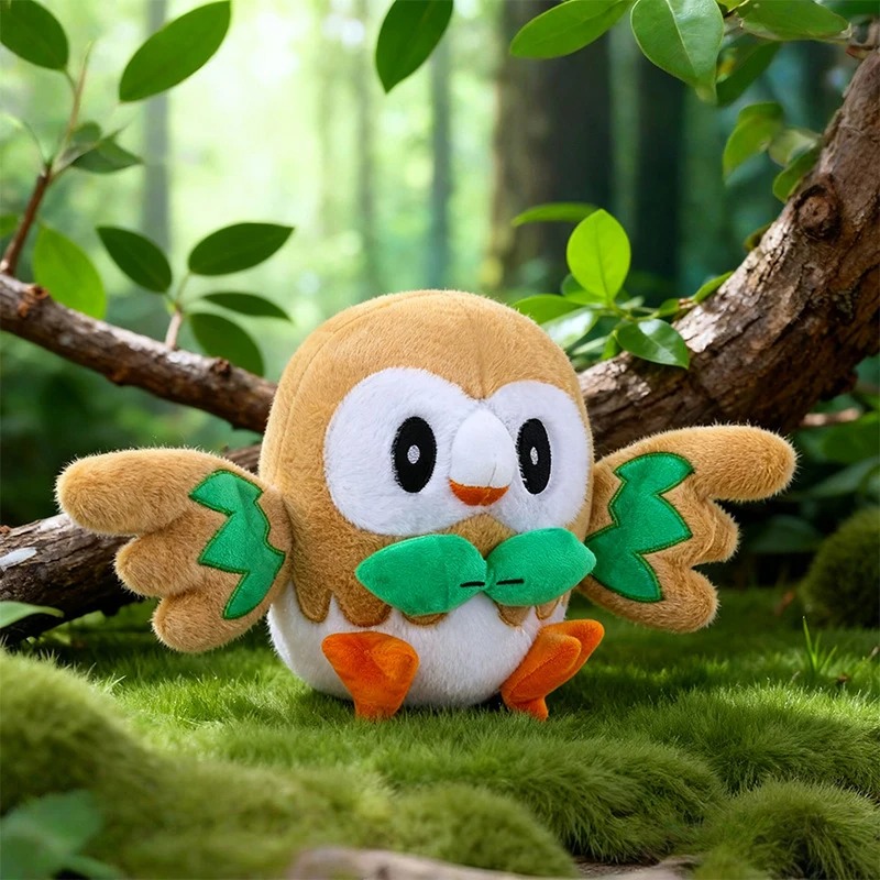 Pelúcia do Rowlet, de Pokémon, sobre musgo em cenário de floresta
