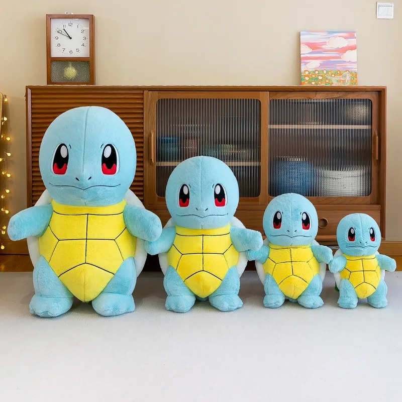 Quatro pelúcias do Squirtle em tamanhos diferentes lado a lado sobre um móvel