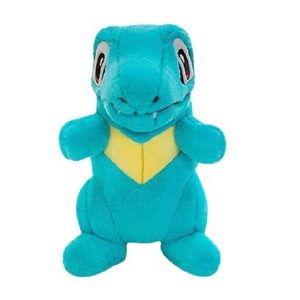 Pelúcia do Totodile, de Pokémon, de frente, azul-turquesa com peitoral amarelo
