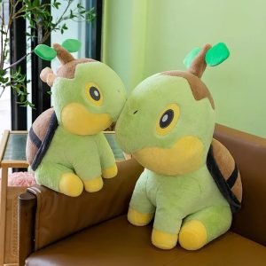 Duas pelúcias do Turtwig, de Pokémon, verdes com broto na cabeça e casco marrom, sobre um sofá