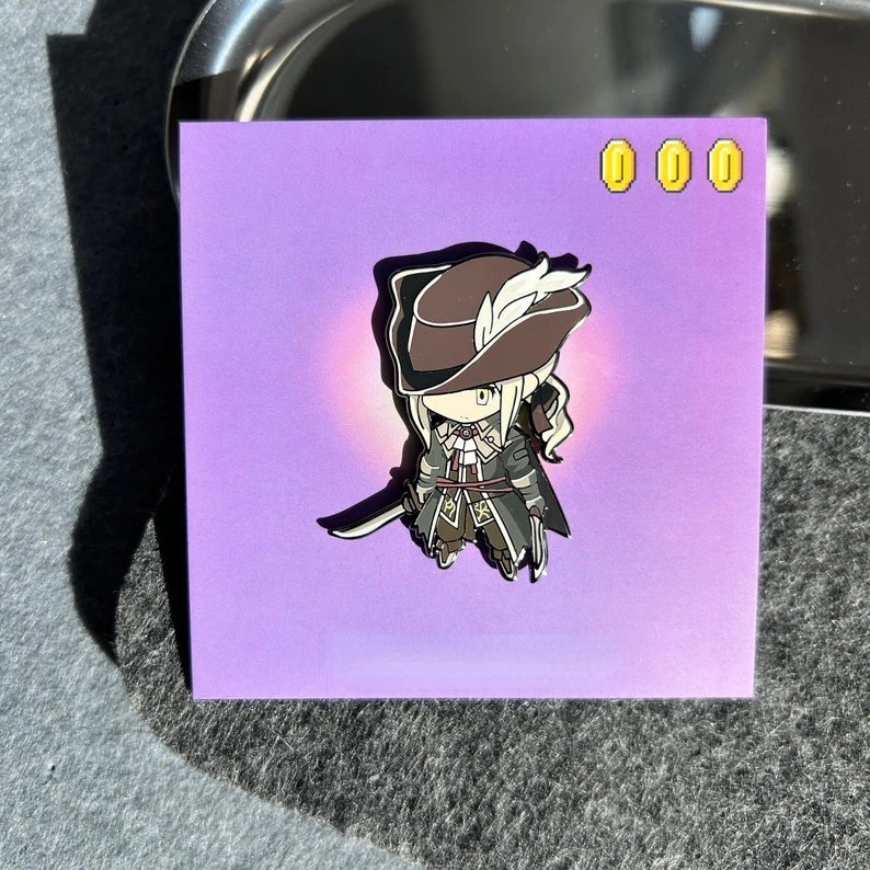 Pin esmaltado chibi de Bloodborne, personagem de chapéu de abas largas, sobre cartela roxa