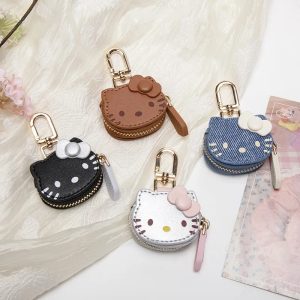 Quatro mini porta-moedas da Hello Kitty nas cores marrom, preta, azul e prata, sobre tecido branco