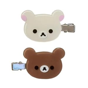 Presilhas do Rilakkuma, marrom, e da Korilakkuma, bege, com grampo de metal, sobre fundo branco